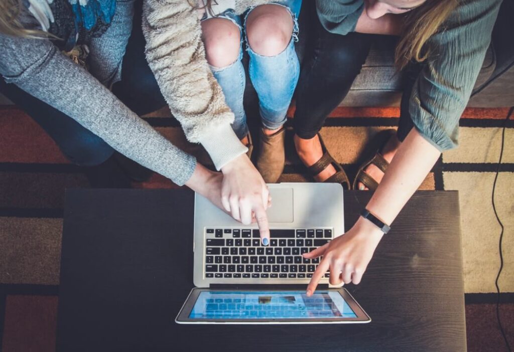 Two people collaborating on a laptop computer