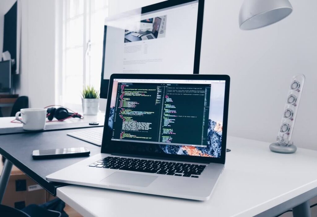 Laptop on a desk with a coding application open